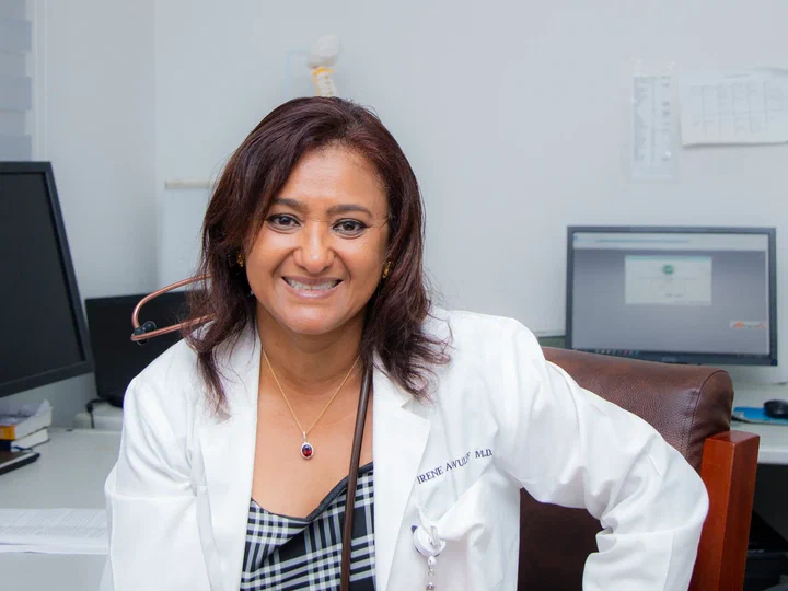 Dr Irene Adorkor Wulff, CEO of FOCOS Orthopedic Hospital, smiling in a white coat at her desk