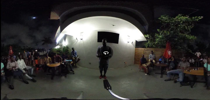 360-degree night view of Darlington Ahiale Akogo speaking to an audience at the first Science Cafe, August 2018