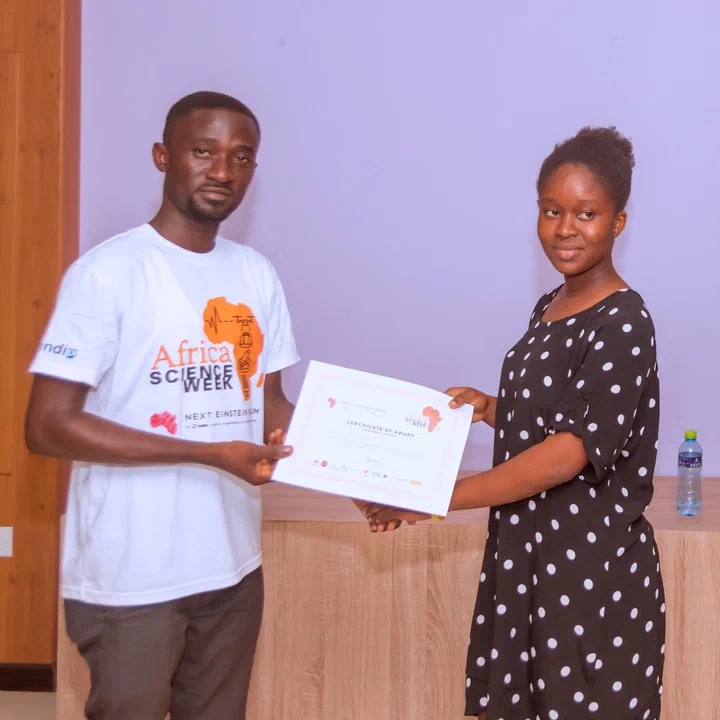 NEF Ambassador Peter Asare-Nuamah, in an Africa Science Week T-shirt, hands a certificate to one of the winners